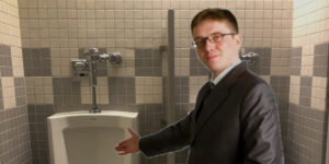 “Need a Hand?” Mann Library Pecker Peeper Reaches Right Over Urinal Divider
