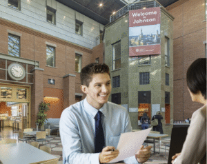 Student in Suit Evaluates, Judges Slightly Younger Student in Suit